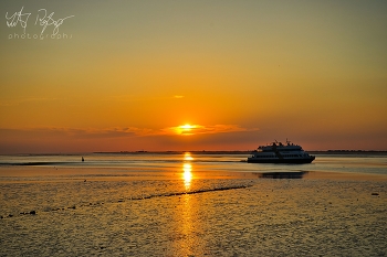 Nachhause kommen / Sonnenuntergang an der Nordsee mit Schiff
