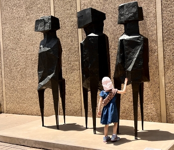 Handshake / Girl shaking hands with a monument in Bilbao park, San Diego