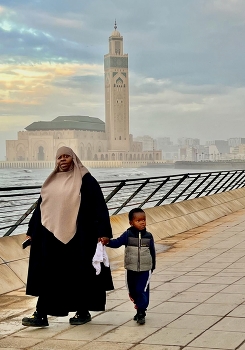 Casablanca / Mother and child walking past the famous mosque