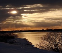 Sonnenuntergang über einem Fluss. / ***