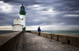 The fisherman / The lighthouse of le Tréport in Normandy (France)