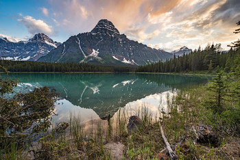 Mount Chephren (3266m) / Dieses Bild entstand auf einen nicht geplanten Stopp auf dem Icefield Pkwy im Banff Nationalpark (Kanada). Als ich die perfekte Spieglung im Wasser sah habe ich die Kamera geschnappt und mich zwischen tausenden Mücken in Position gestellt. Ich musste viel von Ihnen aus dem Bild stempeln, da ich keine Tiere fotografieren wollte ;), sondern Landschaft. Aber wenigstens haben einige der Mücke auch noch Abendbrot von mir bekommen.