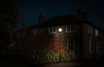 Cart wheels under gas light / Composition of a night shot showing three cart wheels illuminated by an old gas lamp post.