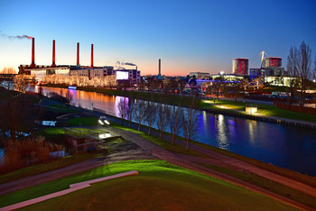 Car city of the future / Ein Blick über den Mittellandkanal, die alten Schornsteine des Kraftwerkes, die moderne Autostadt in Wolfsburg zur blauen Stunde