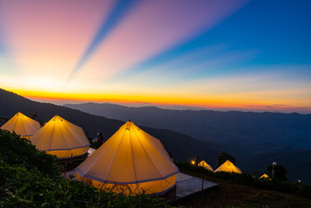 Camping with crepuscular rays after sunset background / Camping and white tent on the hill with crepuscular rays after sunset background, Chiangrai Thailand
